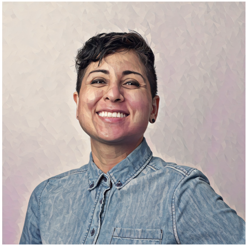 Tamira Benitez of Diverse City fund smiles in front of a blurred background wearing a denim button down shirt.