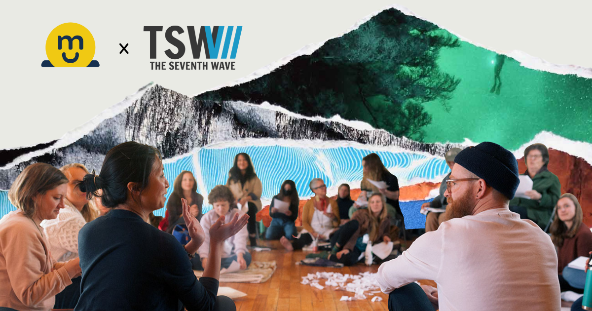 A group of people is seated in a circle in front of a background collage of waves with the logos of Magic Cabinet and The Seventh Wave represented.