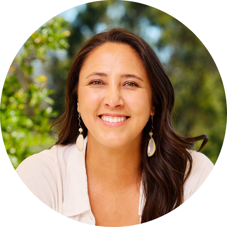 Picture of Charlotte Basch-Lin. Charlotte appears in front of a nature background and wears a white top and iridescent earrings.