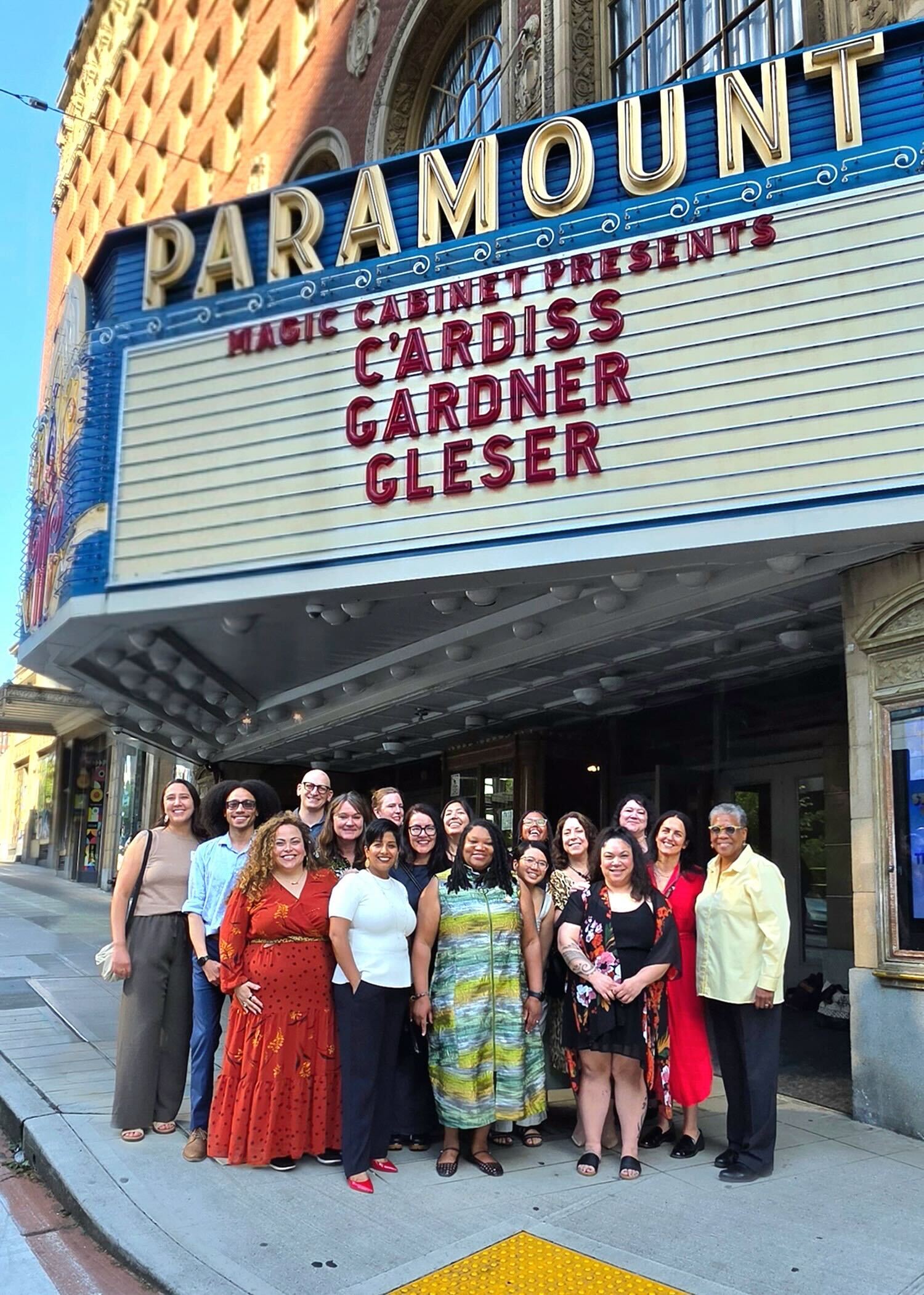 A group of people stand underneath a marquee that reads Magic Cabinet presents C'Ardiss Gardner Gleser